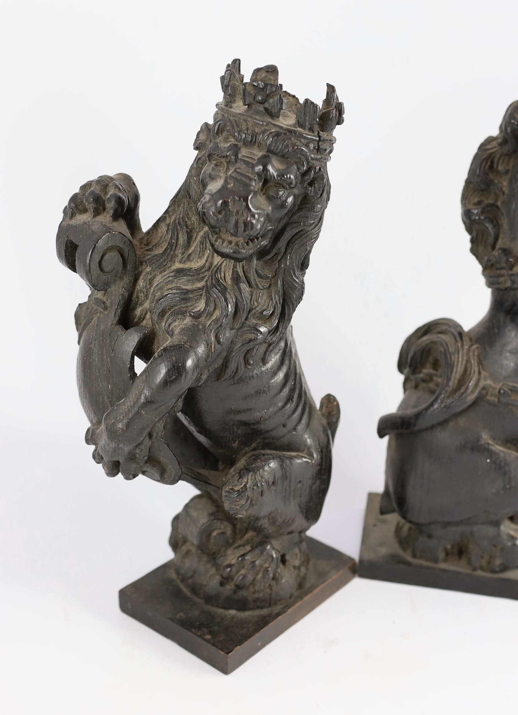 A pair of 18th century carved and ebonised oak heraldic beasts, lion and unicorn, 42cm high
